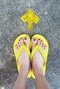 Yellow Arrows Direction. WomanÃ¢â¬â¢s Sandals Feet with Violet Nail Pedicure on Cement Background